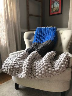 a white chair with a blue and black blanket on it