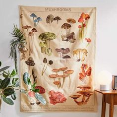 a mushroom tapestry hanging on the wall next to a table with a potted plant