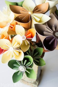 a vase filled with paper flowers on top of a table