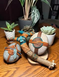 some rocks are sitting on a table with succulents and plants in them