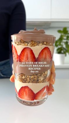 a person holding up a glass with some food in it and the words 30 days of high energy breakfast