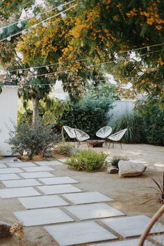 an outdoor patio with chairs and trees in the background