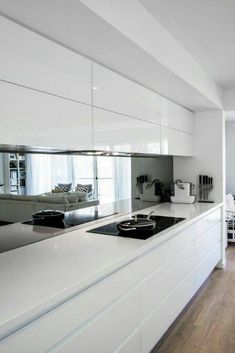 a kitchen with white cabinets and counter tops