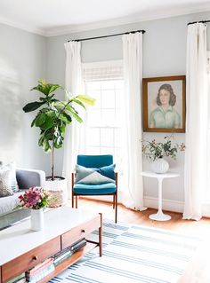 a living room filled with furniture and a painting on the wall