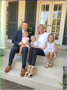 a family sitting on the front steps of a house