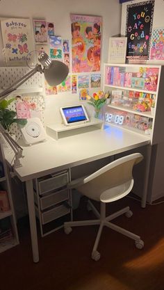 a white desk with a laptop on top of it next to a book shelf filled with books