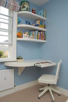 a white desk and chair in a blue room with bookshelves on the wall