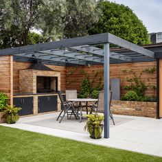 an outdoor kitchen and dining area in a backyard