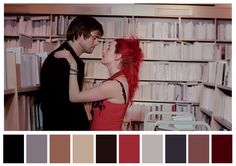 two people standing next to each other in front of bookshelves with red hair