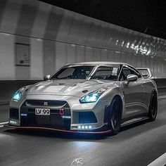 a silver sports car driving down a tunnel