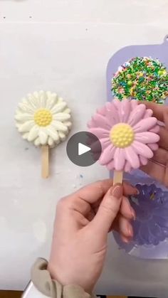 someone is decorating fake flowers with colored sprinkles