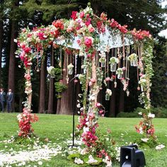 an outdoor wedding ceremony with flowers on the altar