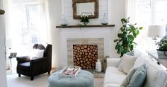 a living room filled with furniture and a fire place in front of a mirror on the wall