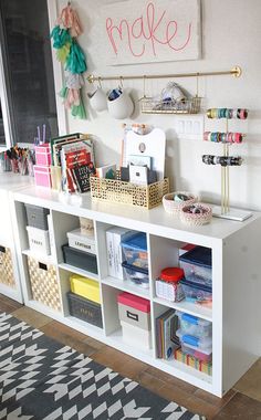 a white bookcase with lots of craft supplies on top of it and hanging from the wall