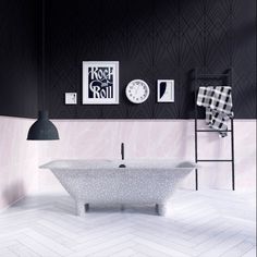 a bathtub sitting in the middle of a room with black and white wallpaper