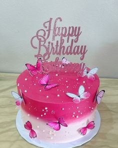 a pink birthday cake with butterflies on it