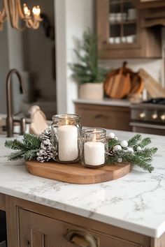 candles are sitting on top of a wooden tray in the middle of a kitchen counter