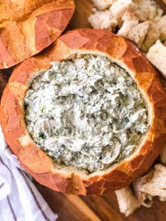 a bread bowl filled with spinach dip