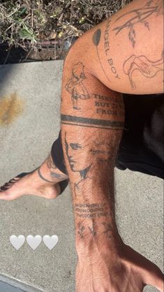 a man's leg with tattoos on it and hearts in the ground next to him