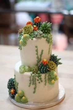 a three tiered cake decorated with succulents