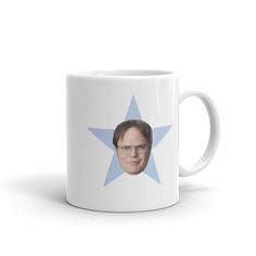 a white coffee mug with a blue star on the side and a man's face