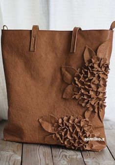 a brown leather bag with flowers on it