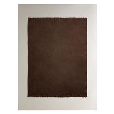 a brown piece of cloth with fringes on it