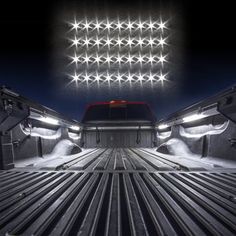 the interior of a truck with lights on and snow in the bed area at night