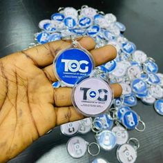 a hand holding a keychain that is covered in blue and white buttons