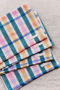 three different colored plaid cloths folded on top of each other