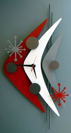 a red and white clock on the side of a building with snowflakes hanging from it's sides