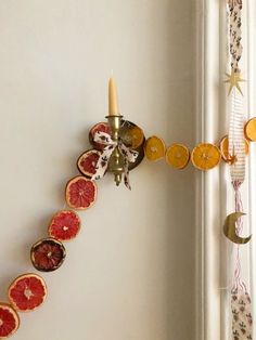 a wall mounted clock made out of grapefruits and orange slices with a candle in the middle