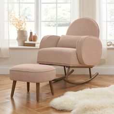 a rocking chair and foot stool in front of a window with white fur on the floor