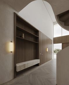 an empty room with shelves and lights on the wall, along with wooden flooring