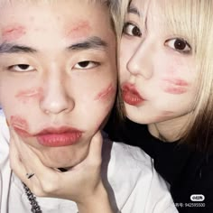 two people with makeup on their faces posing for the camera