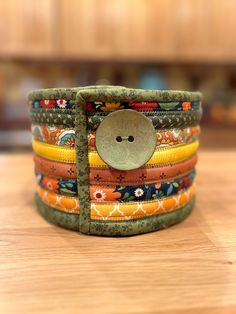 a stack of multicolored bracelets with a button on the front and bottom