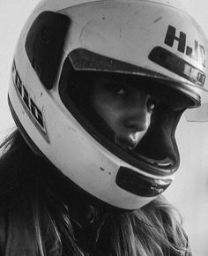 black and white photograph of a woman wearing a helmet with the word hh on it