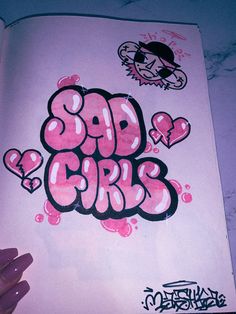 someone is holding up a book with graffiti written on it and the words bad girls