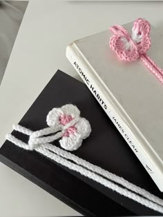 a book with two crocheted flowers on top of it