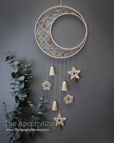 a white dream catcher hanging from the side of a wall