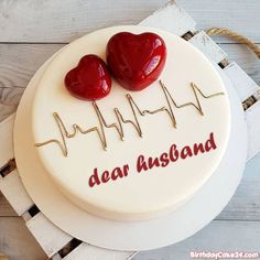 a cake with two hearts on it and the words dear husband written in red icing