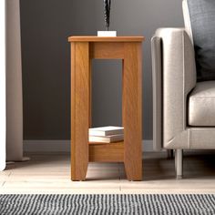 a small wooden table with a flower on it next to a couch and chair in a living room