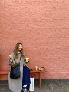 a woman is sitting on a bench and eating