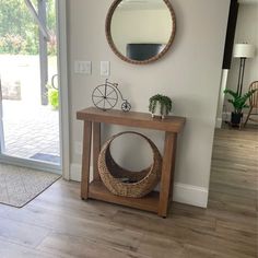 a wooden table sitting in front of a door with a mirror on it's side