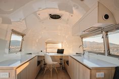 an interior view of a camper with white counter tops