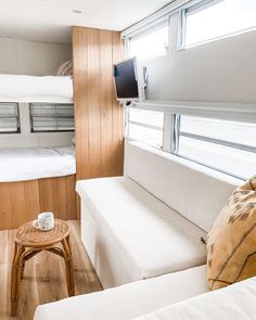 a room with bunk beds and white couches