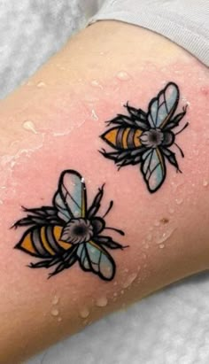 three bees on the side of a woman's leg with yellow and black ink