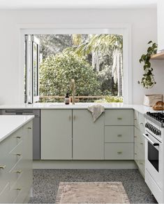 a kitchen with an oven, dishwasher, and window in the middle of it