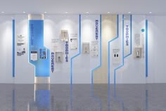 an empty room with blue and white signage on the wall next to phone booths in it