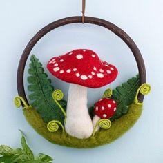 a small red mushroom sitting on top of a green leafy plant in a circle